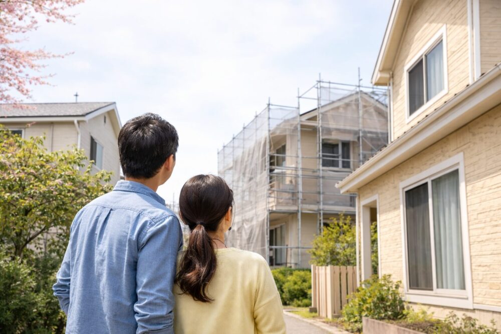 隣家の塗装作業を見守る二人