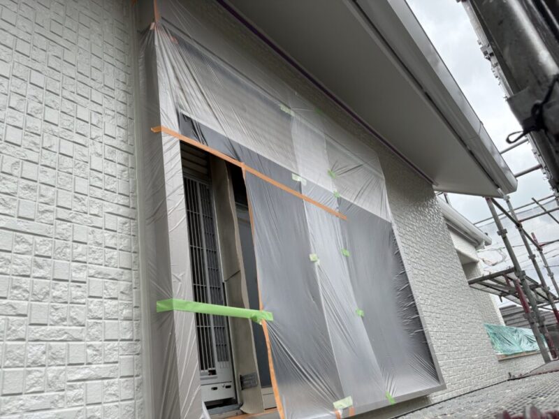 外壁塗装前に窓まわりをビニールとテープで養生している様子