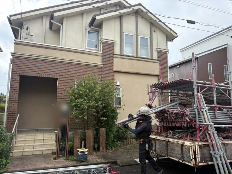 佐倉市ユーカリが丘の外壁塗装現場で、足場材を搬入する職人