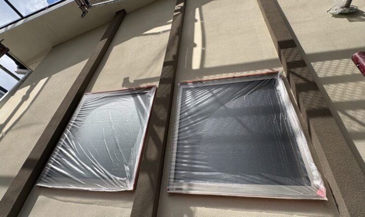 外壁塗装前に窓ガラスとサッシをビニールシートとテープで保護した養生作業