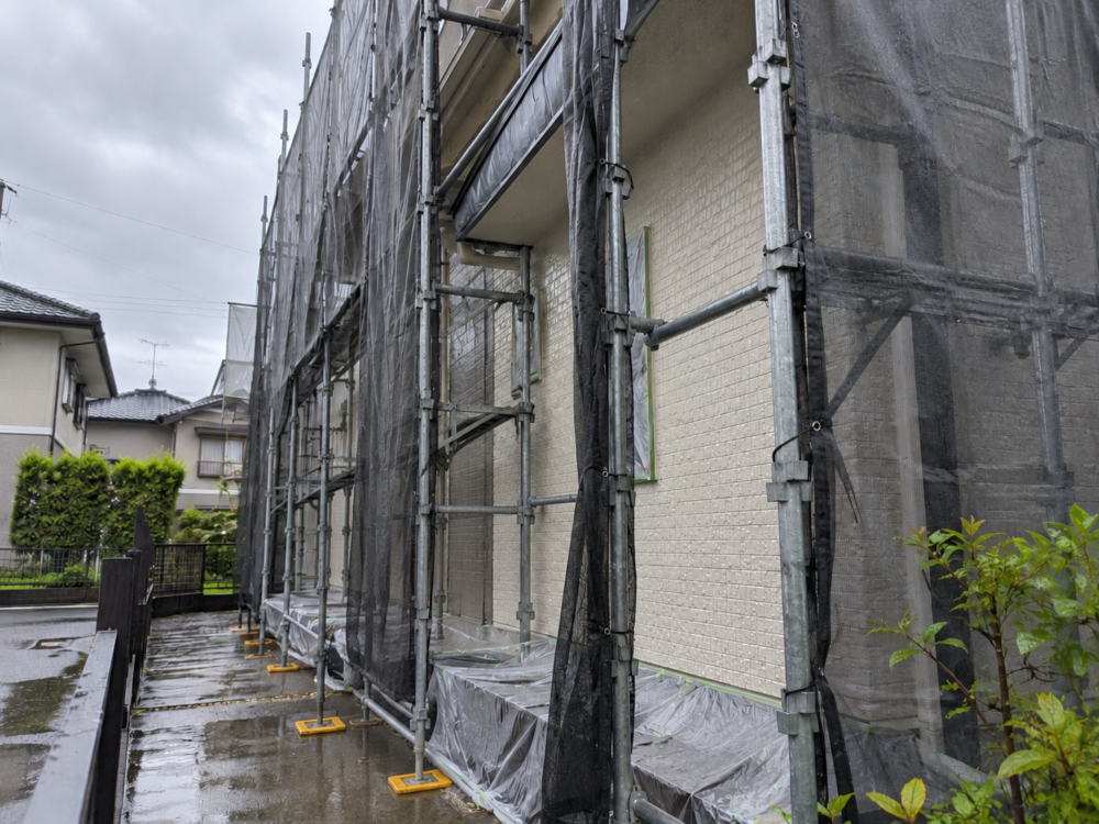 雨に濡れた住宅改修現場と足場